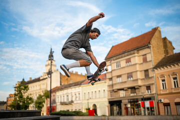 Skateboarder performing ollie trick in city square © Zoran Jesic