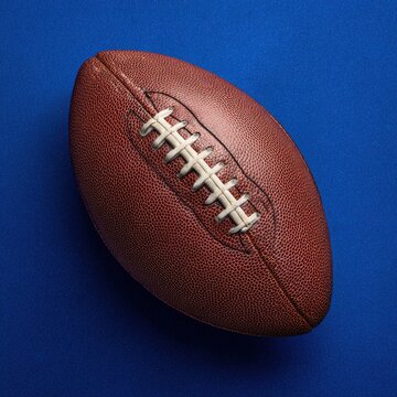 American football ball isolated on blue surface with football american equipment isolated competition professional training exercise background close-up contrast athletic gridiron