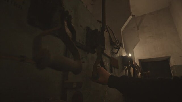 A hand operates a rusty industrial lever against a peeling wall. The concept highlights industrial history and vintage machinery, offering value in historical and industrial contexts.