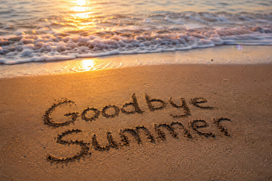 Goodbye summer text a beautiful message on the beach sand, symbolizing the end of vacations holidays, as the sunny sea waves greet the ocean under the bright sunlight on coastline