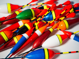 Colorful fishing bobbers floating on still water © VexoraImages