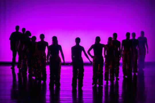 Group of dancers performing on stage in a bright purple silhouette