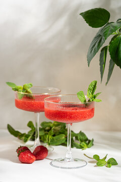 Two strawberry cocktails garnished with fresh mint for summer