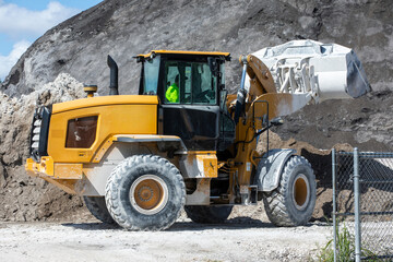 Fototapeta premium Yellow wheel loader carrying sand at a concrete batching plant