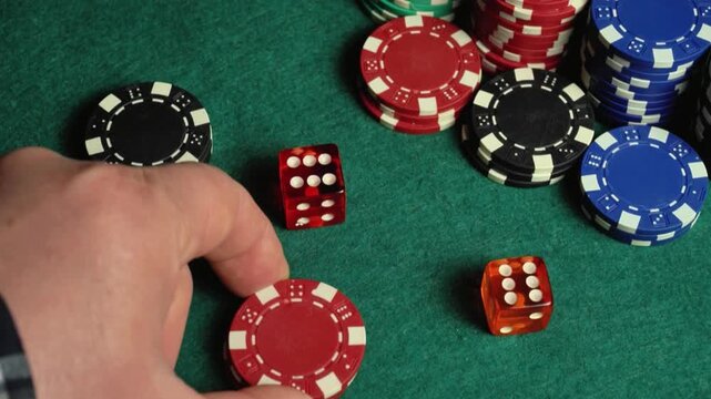 A hand moves to place poker chips and dice on a green felt table, illustrating a continuous sequence of actions in a gaming environment with different colored chips and dice