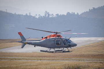 Fototapeta premium Helicopter taking off from airport runway during day