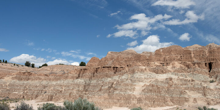 Panorama of blue sky and white clouds over a rock wall at Cathedral Gorge State Park in Nevada