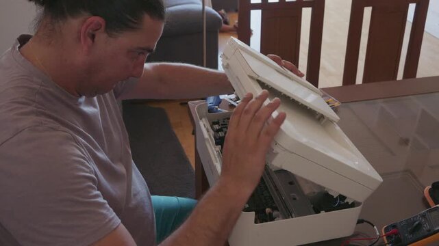 Man attempting to repair a broken printer