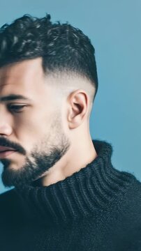 Portrait of a stylish man with dark curly hair, beard, and intense gaze, dressed in a cozy black sweater. Contemporary fashion and confident attitude are captured in this studio shot