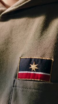 Vertical video: Shifting camera showing chest rising in room, showing star patch on hoodie pocket