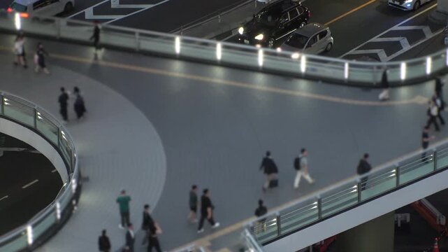 TOKYO, JAPAN - JUNE 2026 : Aerial view of crowd of people walking at the pedestrian deck. Street traffic and highway overpass. Japanese city traffic and transportation concept, time lapse video.