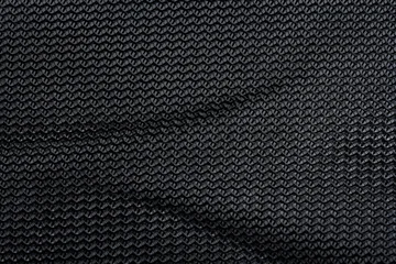 Black textured mesh fabric with folds and woven pattern close up background © aninna