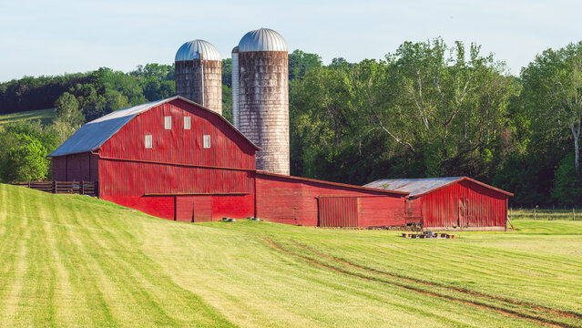 Iconic red barn against a vibrant green grass lawn, reminiscent of classic rural American farmland