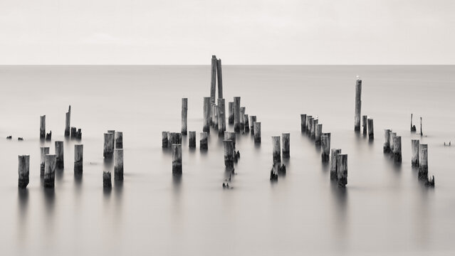 Long exposure image of pylons at the oceanfront with smooth calm and peaceful looking water