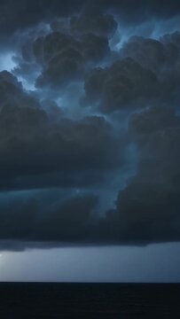 Vertical video: Flashing inside tall storm cloud, internal lightning brightening lobes over ocean