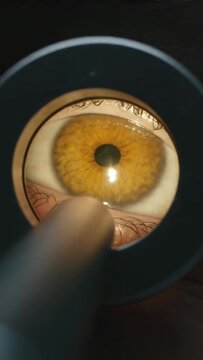 Vertical video: Moving penlight touching lower lid as ringlight lighting amber iris in clinic exam