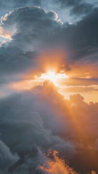 Vertical video: Emerging sun piercing towering cloud, casting golden rays through gap at sunset