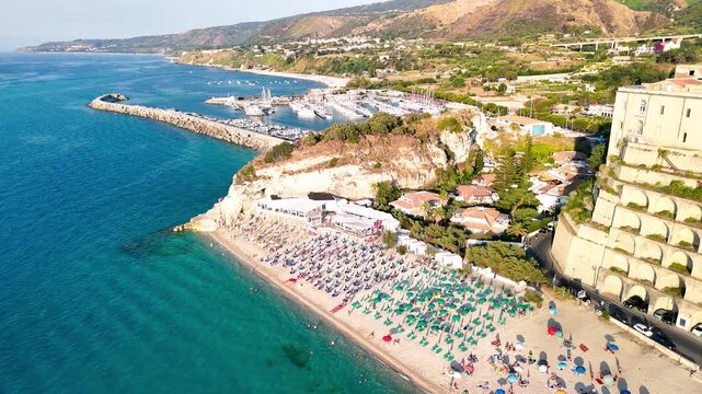Stunning overhead drone perspective capturing the endless golden beaches dotted with colorful umbrellas, the medieval city center with its narrow cobblestone streets