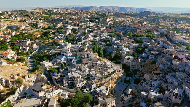 Drone view of Ortahisar, Cappadocia, Turkey town. Stone rooftops, narrow roads and rocky formations fill a scenic Cappadocia panorama.