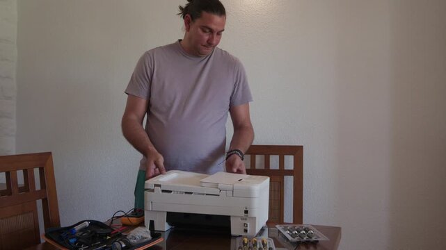 Technician installing ink cartridges into a new multifunction printer at home