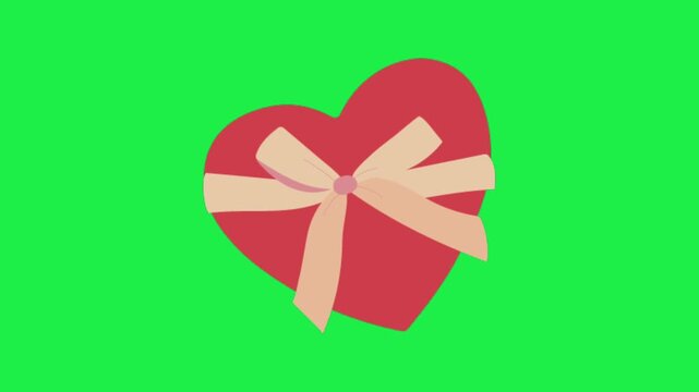 Red heart shaped chocolate box with a beautiful ribbon bow isolated on a green screen chroma key background
