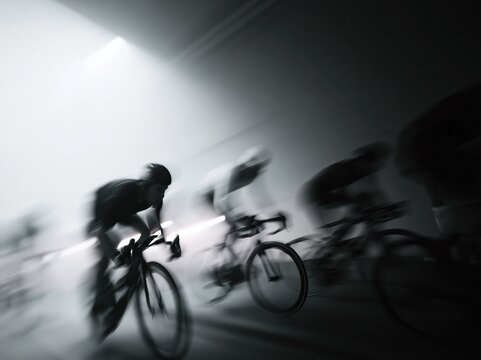 Cyclists racing intensely in a blur of motion, capturing the speed and competition