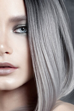 Female model showing partial face behind straight hair in studio