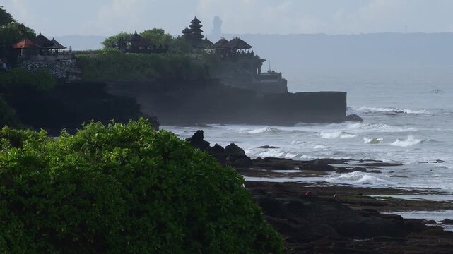 Rough Waves Rocky Coastline Tanah Lot Temple Silhouette With Pounding Surf, Windblown Spray And Bouldered Foreground, Dramatic Clouds, High Tide Motion, Cinematic Seascape For Travel And Storm Footage