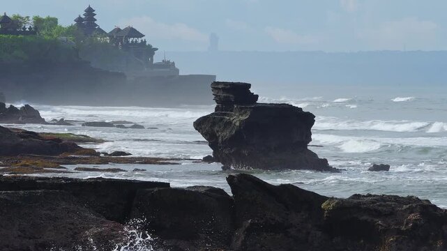 Silent Coastal Temple. Misty Shoreline With Ancient Shrine. Eroded Rocks Leading To Tranquil Sacred Site. Serene Landscape Featuring Weathered Stones And Distant Spiritual Monument, Tanah Lot temple