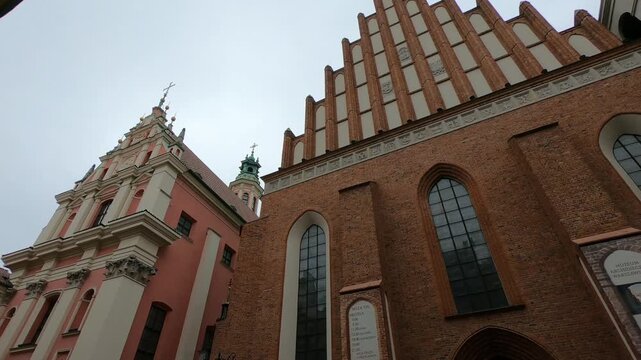 Warsaw / Poland - April 28, 2019: PAN SHOT SLOW MOTION - Warsaw old town. St. John's Archcathedral and Shrine of Our Lady of Grace the Patron of Warsaw.