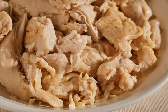 A bowl of cooked chicken pieces.