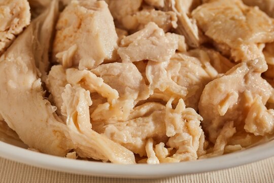 A bowl of cooked chicken pieces.