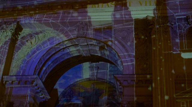 Projection mapping show on historic cathedral facade. Colorful video mapping projection illuminating the ancient architectural details of a historic church facade at night during a light festival