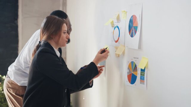 Man and woman work in office, analysts examining reports and marketing research. Teamwork and partnership, African American and Caucasian ethnicity, international corporation, business startup