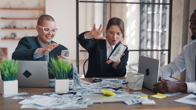 Employees of big company enjoying good salary and benefits, throwing money. Joyful male and female office workers throwing cash dollar banknotes, slow motion shot, good mood and positive emotions
