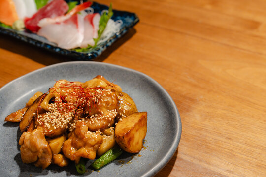 飲食店を演出する鶏肉とさつまいものの炒め物と新鮮な刺身。メニューやグルメ記事用