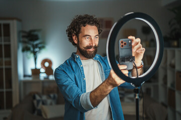 Man creating video content with smart phone and ring light © Miljan Živković