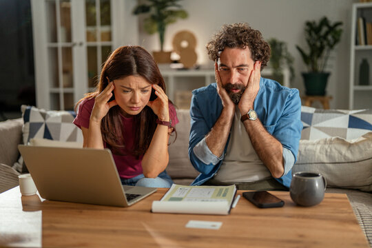 Stressed young couple managing financial problems at home