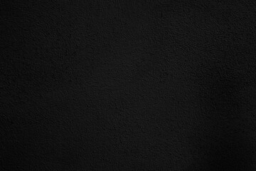 Fototapeta premium Textura de pared grunge negra, fondo superficial oscuro y rugoso. Superficie de pared oscura, rugosa y granulada con textura de ruido sutil. Fondo versátil para diseño editorial y de carteles.