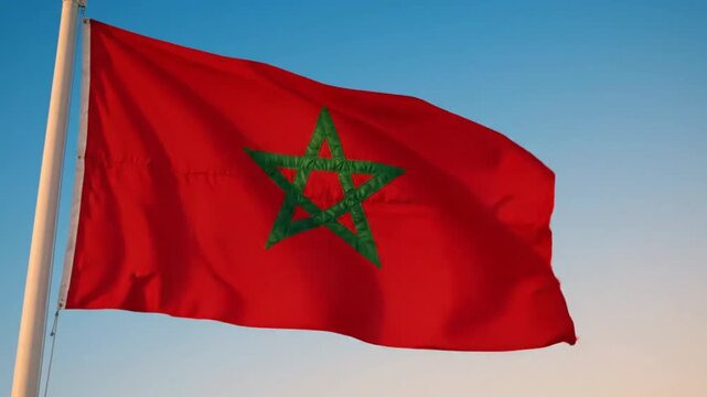 The national flag of morocco waving against a clear blue sky