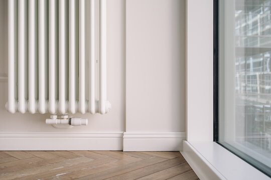 Home heating radiator mounted on wall in modern apartment living space