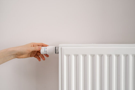 Modern apartment heating radiator being adjusted for temperature control