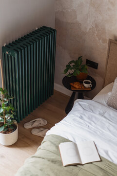 Cozy bedroom with green home heating radiator and simple decor in a relaxing space