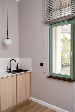 Modern minimalist kitchen with black sink, faucet and wooden cabinets