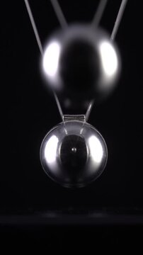 Newton's Cradle in slow motion. Vertical video.