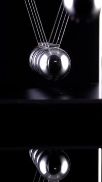 Newton's Cradle in slow motion. Vertical video.