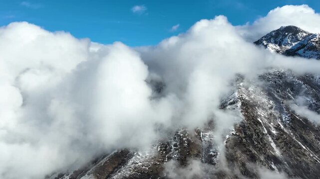 Aerial shot of the clouds and the rugged terrain of the Wasatch Mountains near Salt Lake City, Utah.
