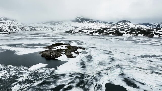 Aerial of a frozen lake and rugged landscape of Norway.