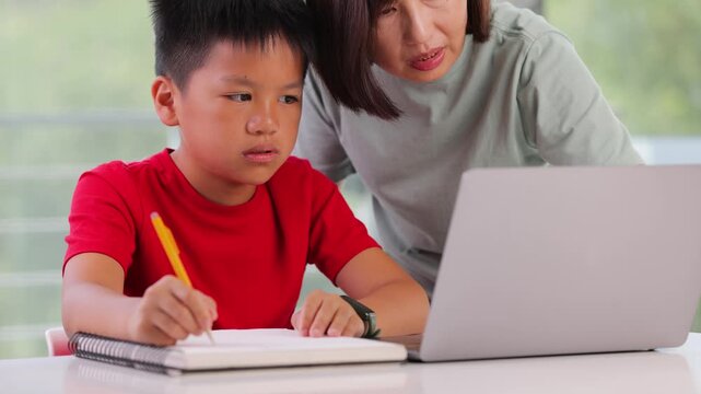 Mother helping her 10 year old son with his homework.