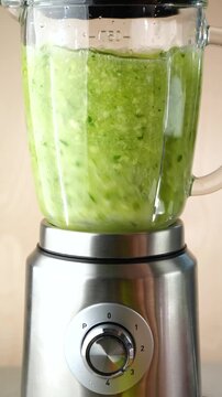 Grind green vegetables and fruits in a blender, making smoothies